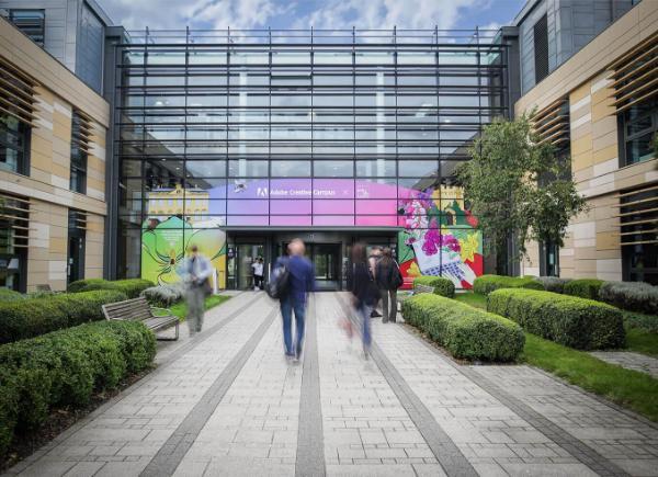 A view of the front of the Commons building, with the brightly coloured Adobe Creative Campus mural on the front