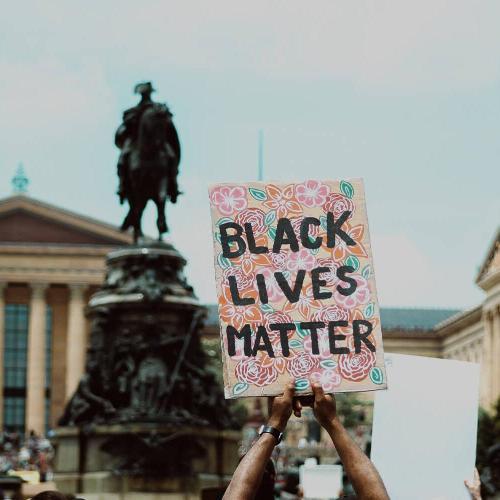 Black Lives Matter placard in front of a statue at a protest.