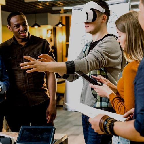 Diverse group of students using a VR headset in a meeting