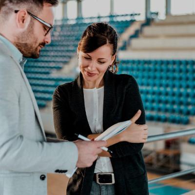 Woman and man in a leisure centre looking at a clipboard.