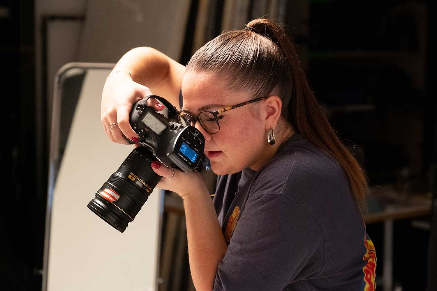 A photography student takes a photo of an object that sits out of shot