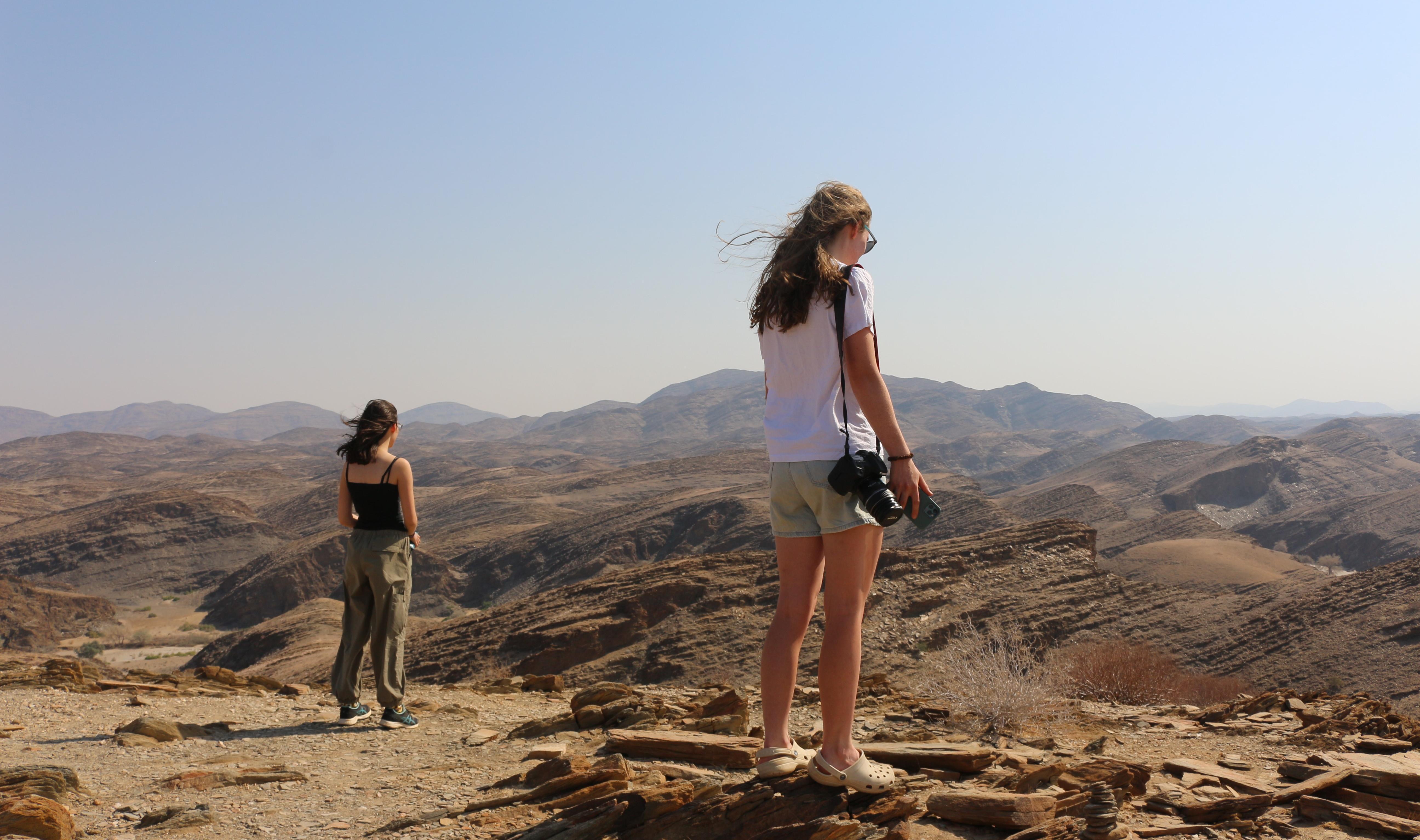Two students look out at mountains on the horizon