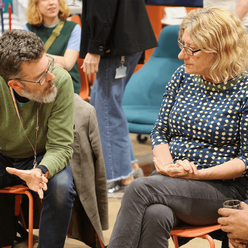 Three people sat on chairs talking to each other