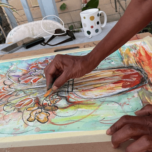 A person using pastels to draw a vase of flowers