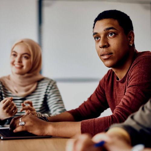 Male student paying attention during class at university