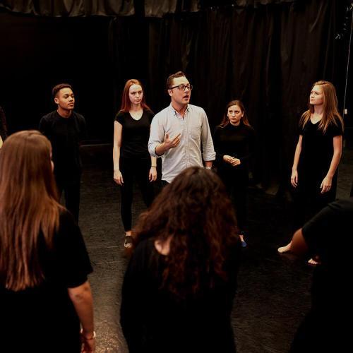 Teacher with drama students in studio