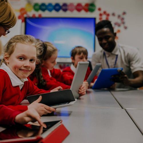 Primary school children in the classroom on tablets