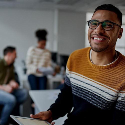 Man with digital tablet smiling to camera in a working environment
