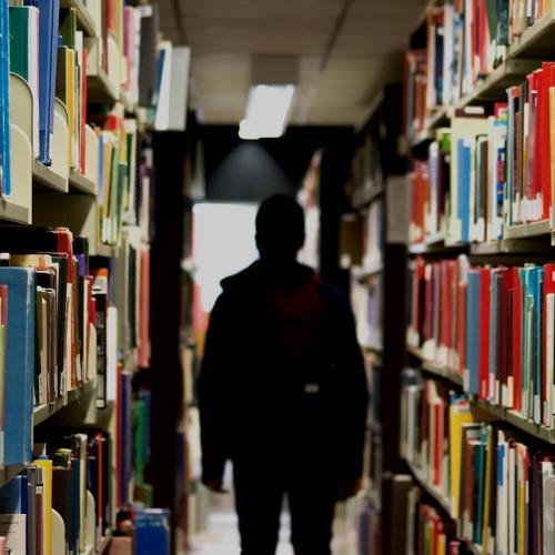 Student walking through a library.