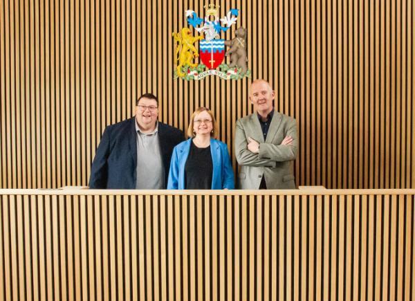 Course Leader Steve Goulton poses with VC Georgina Andrews and Sean McDonough from Mogers Drewett in BSU's mock courtroom