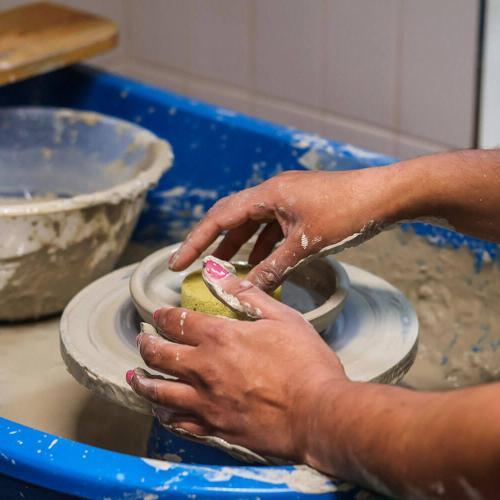 A person's hands molding clay