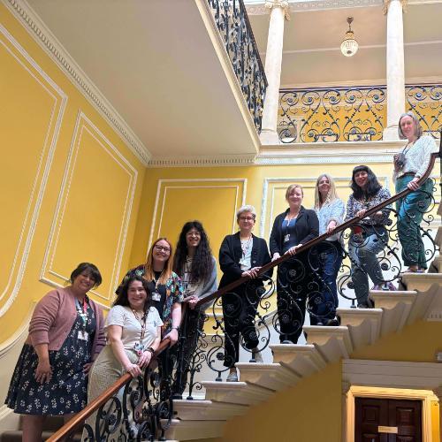 The chairs of BSU's staff networks pose together on a grand staircase