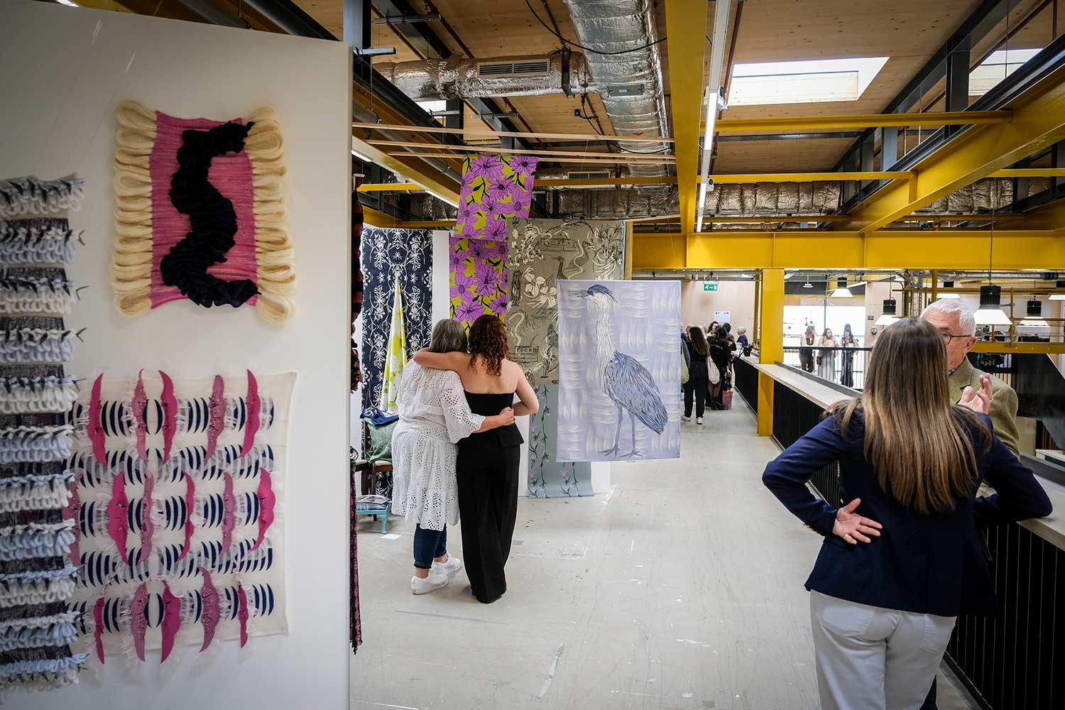 A student shows their artwork to a relative