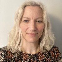 Person with shoulder length blonde hair and floral top