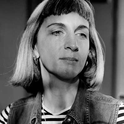 A black and white headshot of a person with a blunt bob and fringe