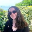 A person wearing sunglasses smiles at the camera