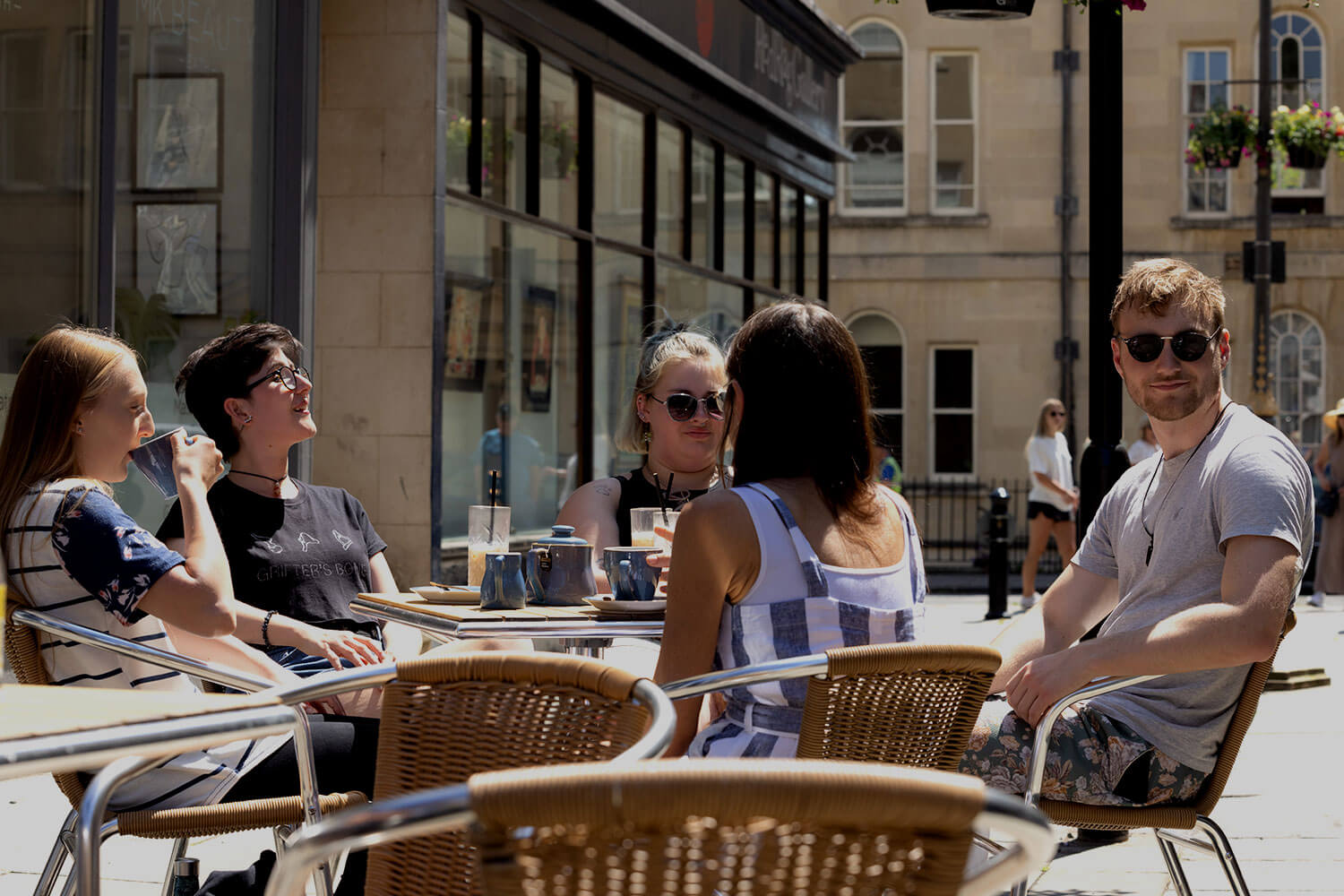 A group of students sitting outdoors at a coffee shop, with Bath